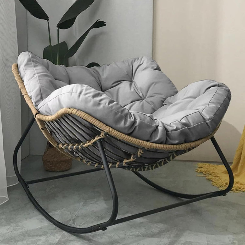 Elegant light grey oversized rocking chair with cushion on patio