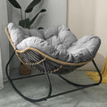 Elegant light grey oversized rocking chair with cushion on patio